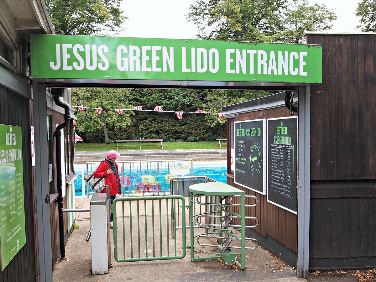 The green entrance gate of Jesus Green Lido with the outdoor pool beyond