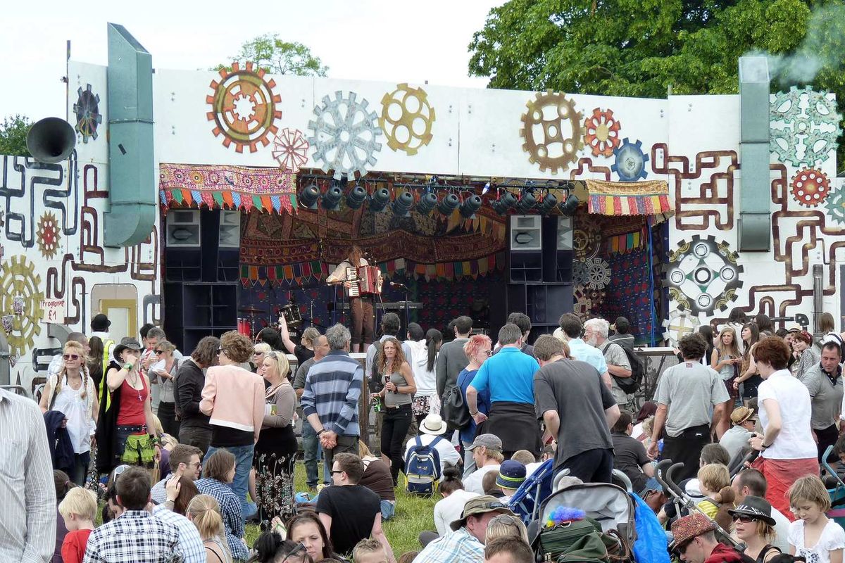 A crowd in front of an outdoor stage at Strawberry Fair on Midsummer Common