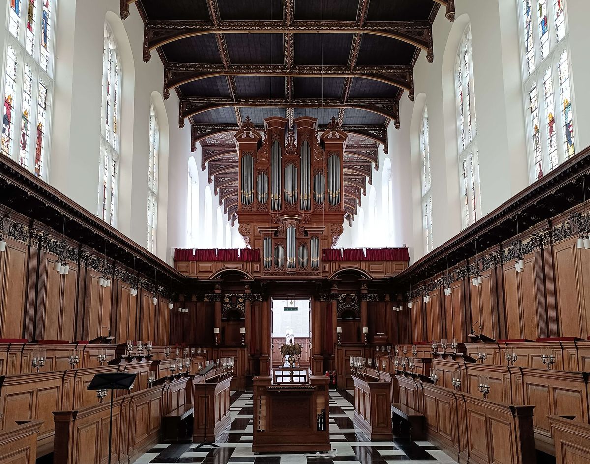 The wood-panelled interior of Trinity College Chapel looking west towards the organ